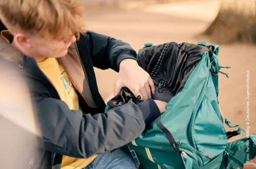 JRKler*in packt einen Rucksack